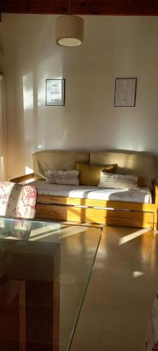 Cama de madera en habitación con sofá en Suite de campo en Chascomús