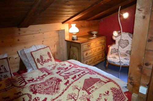 a bedroom with a bed and a dresser and a lamp at Le Vieux Chalet in Gstaad