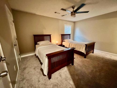 a bedroom with two beds and a ceiling fan at Ecstatic Town Home In Stone Mountain in Stone Mountain