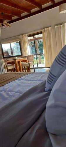 Una gran cama azul en una habitación con ventanas. en Suite de campo en Chascomús