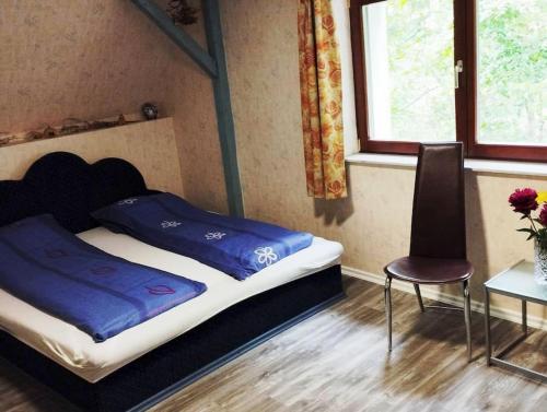ein Schlafzimmer mit einem Bett, einem Stuhl und einem Tisch in der Unterkunft Traumhaftes Ferienhaus im Buchengebirge in Bükkszentkereszt