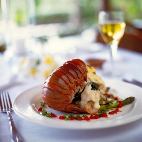 a plate of food on a table with a glass of wine at Yasawa Island Resort & Spa in Mbukama