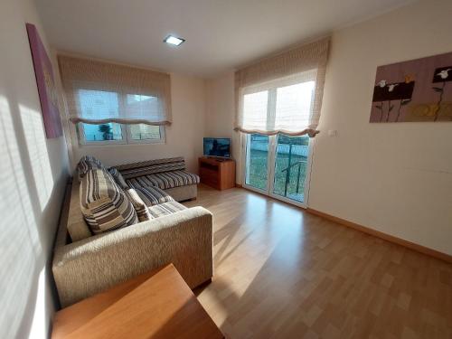 un soggiorno con 2 divani e una TV di Apartamento cerca de la playa a Finisterre
