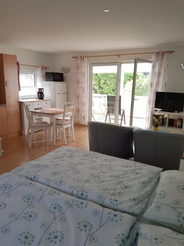 ein Schlafzimmer mit einem Bett und eine Küche mit einem Tisch in der Unterkunft Bungalow in Stralsund