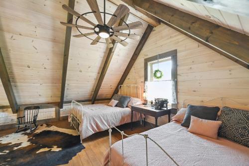 a attic room with two beds and a ceiling fan at Modern Willis Cabin Retreat 24-Acre Working Farm! in Willis