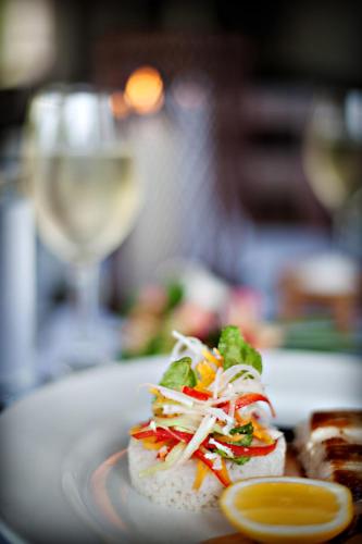 a white plate with food and a glass of wine at Yasawa Island Resort & Spa in Mbukama