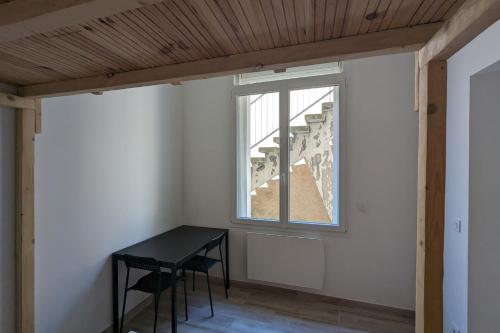 ein Esszimmer mit einem Tisch und einem Fenster in der Unterkunft Comfortable studio of 18 m for 2 people in Montpellier