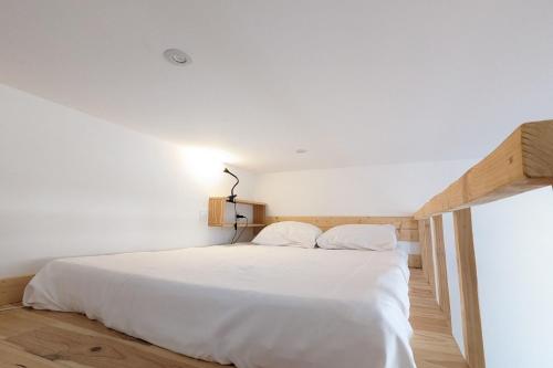 ein Schlafzimmer mit einem weißen Bett mit weißer Bettwäsche in der Unterkunft Comfortable studio of 18 m for 2 people in Montpellier
