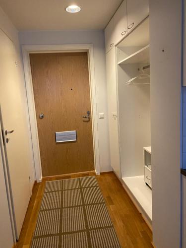 pasillo con puerta de madera y alfombra en Rauhallinen asunto, sauna ja iso parveke - raitiovaunureitin varrella en Tampere