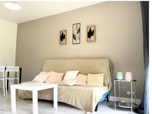 ein Wohnzimmer mit einem Sofa und einem Tisch in der Unterkunft T3 cosy proche Bordeaux et Aéroport in Eysines