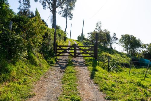 a dirt road with a wooden fence on a hill at Cabañas Mirador Lago Ranco in Lago Ranco