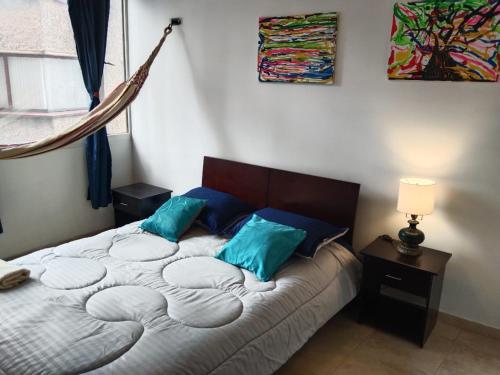 a bedroom with a large bed with blue pillows at Centro Histórico, candelaria -est Las aguas in Bogotá
