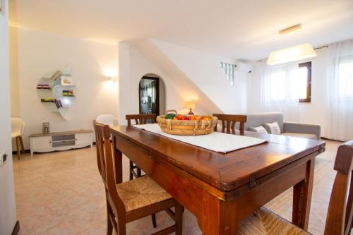 un comedor con una mesa con un bol de fruta. en Isla Country Apartments Alghero, en Santa Maria la Palma