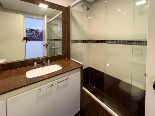 a bathroom with a sink and a glass shower at Camarote VIP Vista Mar e Por do Sol em Ipanema A1-009 in Rio de Janeiro