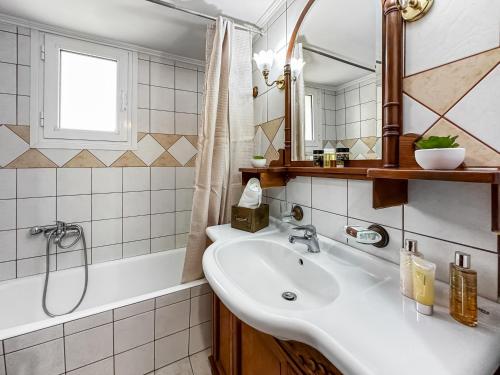 een badkamer met een wastafel, een spiegel en een bad bij Lefkes Apartment in Lygia