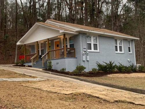 a small blue house with a porch and a driveway at Spring Bungalow - A cozy getaway in downtown Hot Springs! in Hot Springs