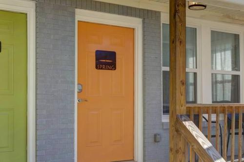 a orange door with a sign on it on a house at Spring Bungalow - A cozy getaway in downtown Hot Springs! in Hot Springs