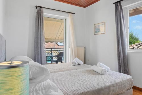a bedroom with two beds and a large window at Lefkes Apartment in Lygia