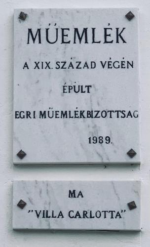 two signs on the side of a building with a street at Agriturismo Villa Carlotta in Szilvásvárad