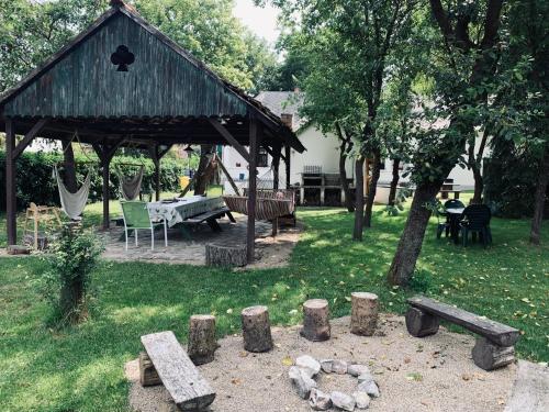 a park with a wooden pavilion with a table and benches at Agriturismo Villa Carlotta in Szilvásvárad