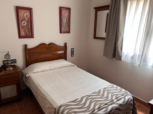 a bedroom with a bed and a window at Hostal Posada Entreviñas in Valdepeñas
