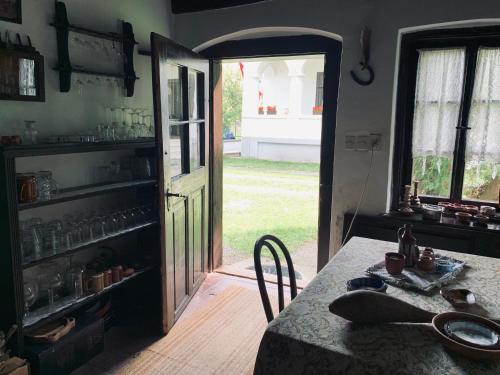 a kitchen with a table and a door to a yard at Agriturismo Villa Carlotta in Szilvásvárad