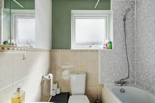 a bathroom with a white toilet and a bath tub at Holiday Home in Canterbury in Kent