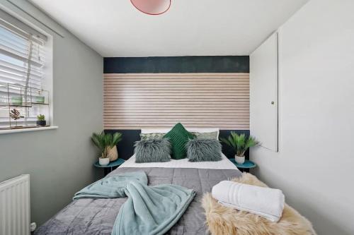 a bedroom with a large bed with blue pillows at Holiday Home in Canterbury in Kent