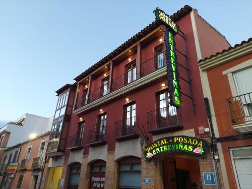 a red building with a sign for a restaurant at Hostal Posada Entreviñas in Valdepeñas