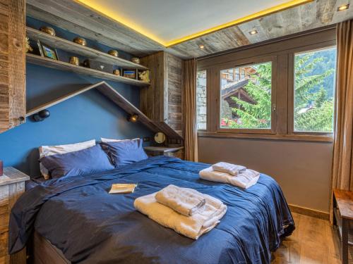 a bedroom with a blue bed with towels on it at Appartement Val-d'Isère, 2 pièces, 4 personnes - FR-1-694-317 in Val-d'Isère