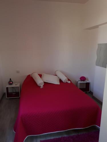 - une chambre avec un lit rose et 2 oreillers dans l'établissement ANDERNOS PRES DE LA PLAGE, à Andernos-les-Bains