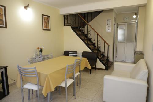 a dining room with a table and chairs and a staircase at MAR & ARENA in Puerto Madryn