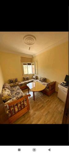uma sala de estar com uma mesa e um sofá em Spacious 2 bedrooms apartment em Al Hoceïma