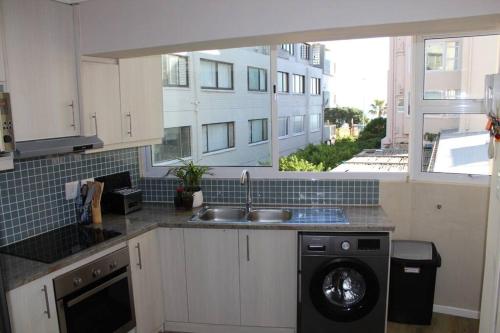 a kitchen with a sink and a washing machine at 16 Serenity Studio - Dolphin Bay in Cape Town