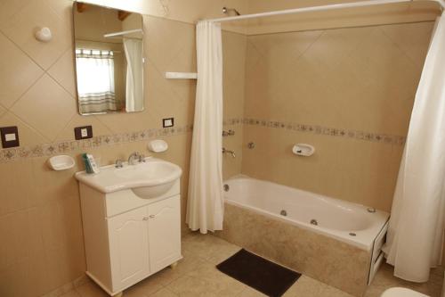 a bathroom with a tub and a sink and a shower at MAR & ARENA in Puerto Madryn