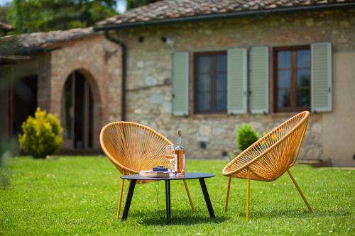 two chairs and a table in front of a house at Poggetto di Montese in San Gimignano