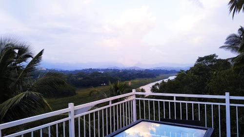a balcony with a table and a view of a road at Mahaweli View Inn in Kandy