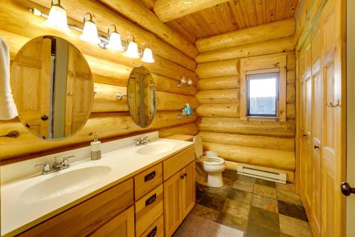 baño con lavabo y aseo en una cabaña de madera en Secluded Log Cabin in NW Michigan Fire Pit and Deck, en Evart