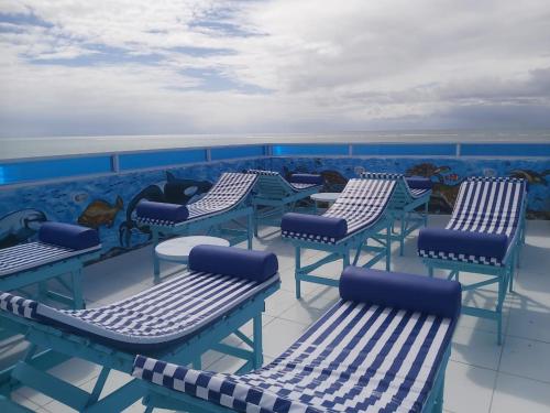 a group of chairs and tables on a deck at Pousada e Hotel Malibu in Paulista