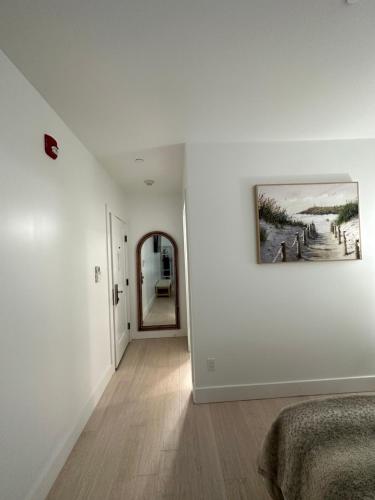 a white hallway with a painting on the wall at Elaine's Cape May Boutique Hotel in Cape May