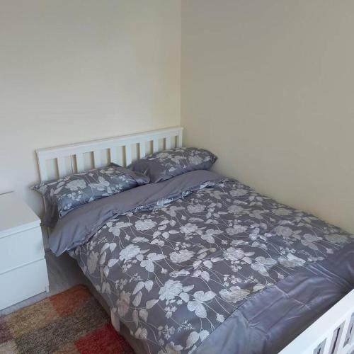 a bedroom with a bed with a blue comforter and pillows at Lovely & Beautiful 2 Bed-Apartment in Borehamwood in Borehamwood