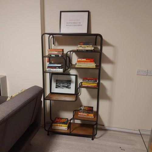 a book shelf filled with books next to a bed at Lovely & Beautiful 2 Bed-Apartment in Borehamwood in Borehamwood