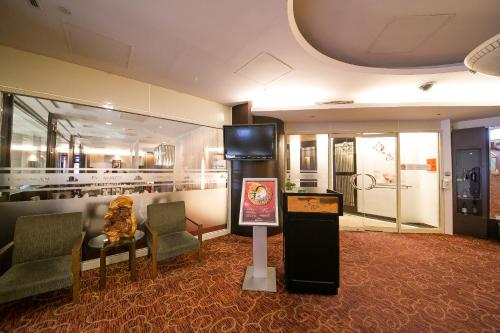 a room with chairs and a tv and a sign at Evergreen Plaza Hotel - Tainan in Tainan