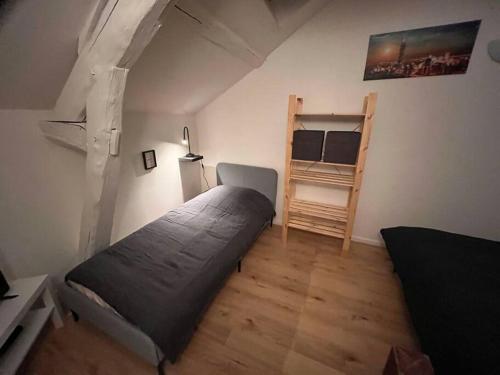 - une petite chambre avec un lit et une échelle dans l'établissement Studio duplex centre-ville au calme avec parking, à Fontainebleau
