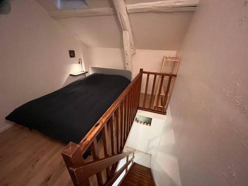 une petite chambre avec un lit et un escalier dans l'établissement Studio duplex centre-ville au calme avec parking, à Fontainebleau