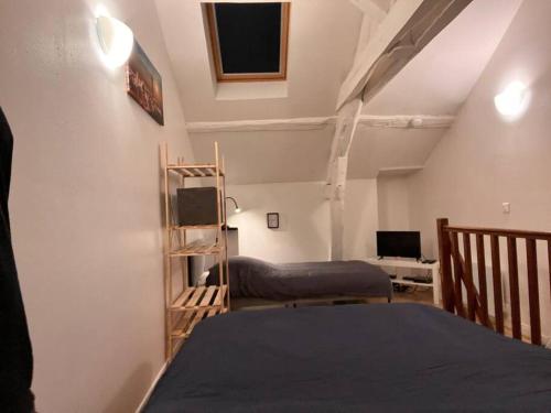 une chambre avec deux lits et un bureau avec un ordinateur dans l'établissement Studio duplex centre-ville au calme avec parking, à Fontainebleau
