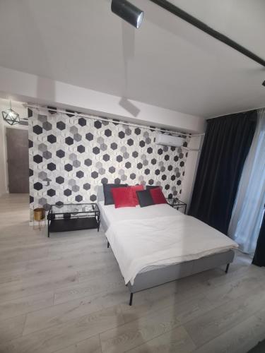 a bedroom with a large white bed with red pillows at Studio 1 camera in Bucharest