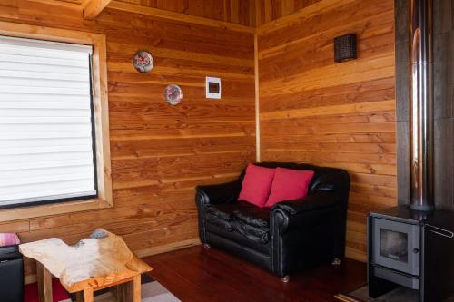 a black leather chair in a room with wooden walls at Cabañas Mirador Lago Ranco in Lago Ranco