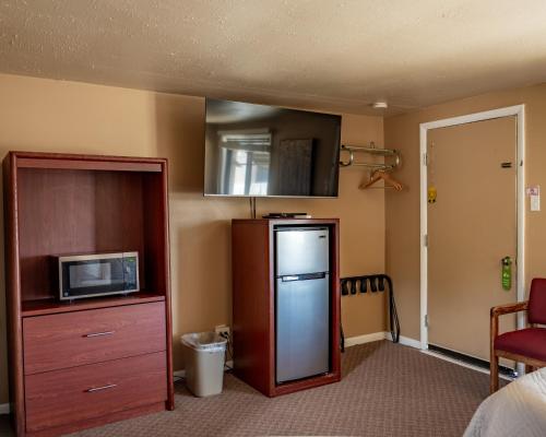 eine Küche mit einem Kühlschrank und einer Mikrowelle in der Unterkunft Oregon Trail Inn in Buhl