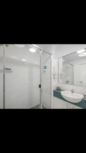 a bathroom with a glass shower and a sink at Tranquil Noosa retreat minutes from the river 40IP in Noosaville